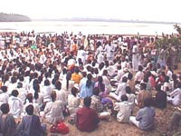 Amma with devotees by the river