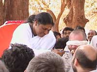 Amma feeding a blindfolded devotee