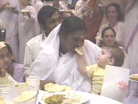 A baby sharing food with Amma