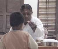 Amma feeds candy to a child