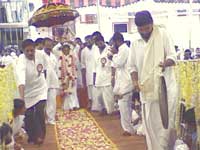 Amma walking under an umbrella