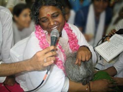 Amma singing bhajans during darshan