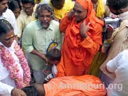 Swami of Narayana Guru Chaitanya Peetham offering padapuja to Amma