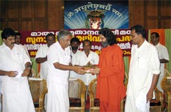 Swami Amritakripananda Puri hands over keys of tsunami houses to Mr. Chandy