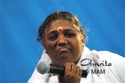 Amma holds a microphone.