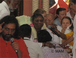 Amma giving darshan and talking on the mike