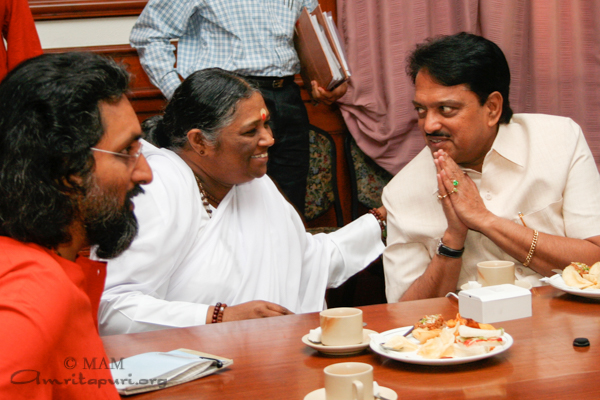 Amma greets member of government at meeting