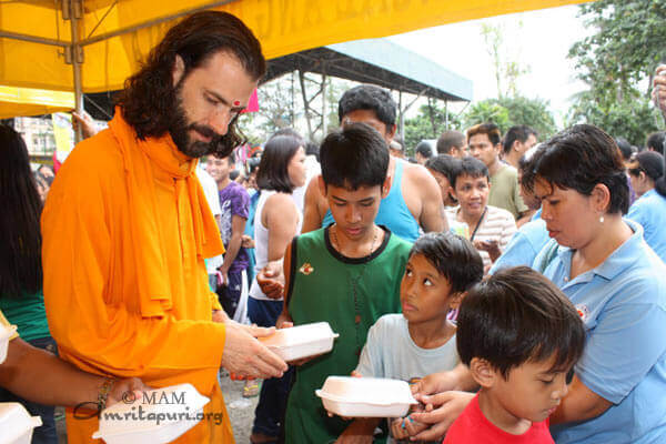 Br. Shantamrita distributing food items to victims of the 2010 fire