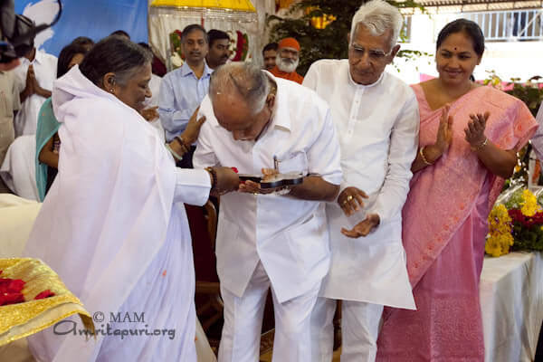 Amma is handing over a symbolic key for the first 100 out of 2,000 houses