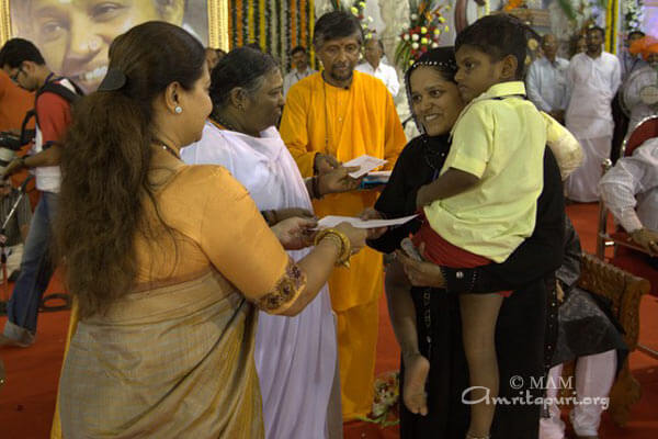 Smita Jayakar helping Amma distribute the Vidyamritam scholarships