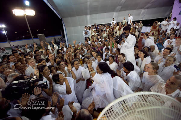 Amma singing and the devotees dancing at the end of darshan