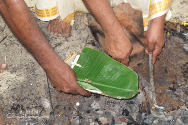 Amma's elder brother collecting some of the ashes for spreading in spiritual locations as per tradition