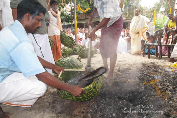 Collecting the rest of the ashes in coconut leaves bags for carrying to the ocean