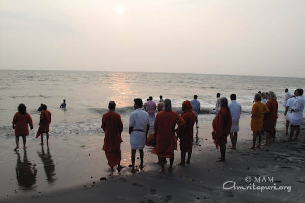 Amma's male family members were joined by the ashram's swamis in performing this duty