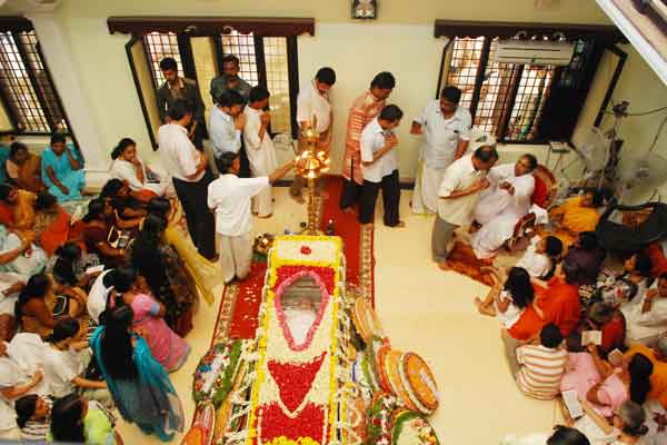 Amma at the parents' house, while devotees pay their last homages to Sugunacchan