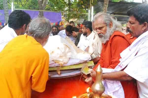 The body is carried outside the house by family members and swamis
