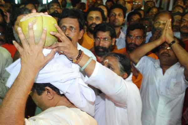 Amma handing over a coconut to her eldest brother Suresh before the body is carried to the cremation grounds