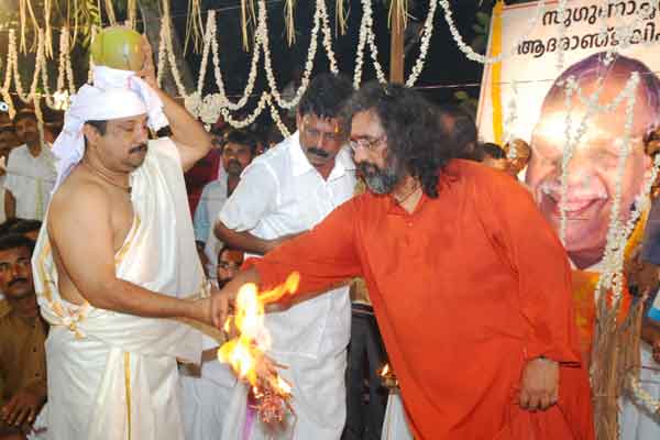 Swami Amritaswaropananda handing over the fire torch to Suresh
