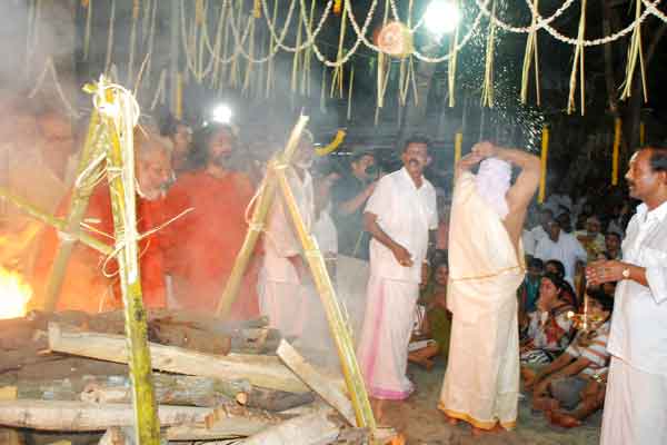 As per the rituals, Suresh, back turned to the body, throws the coconut into the pyre
