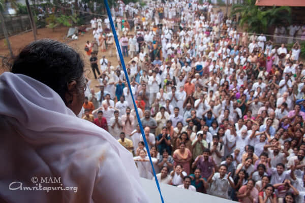 After Darshan, Amma glances compassionately at her children from the balcony