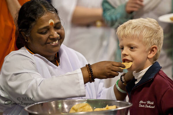 Amma feeding a boy in Australia