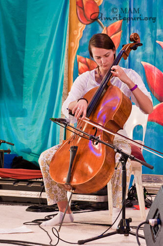 A devotee playing cello for Amma during darshan