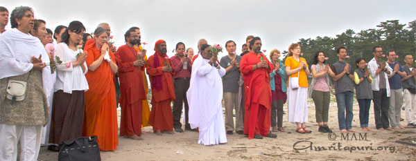 Amma offering prayers and flowers at the sea