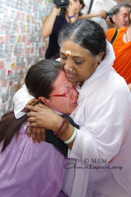 Amma consoling a refugee at the camp