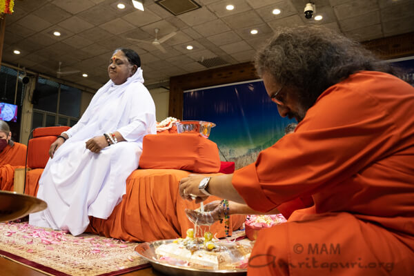 Swamiji performing Paduka Puja in the presence of Amma