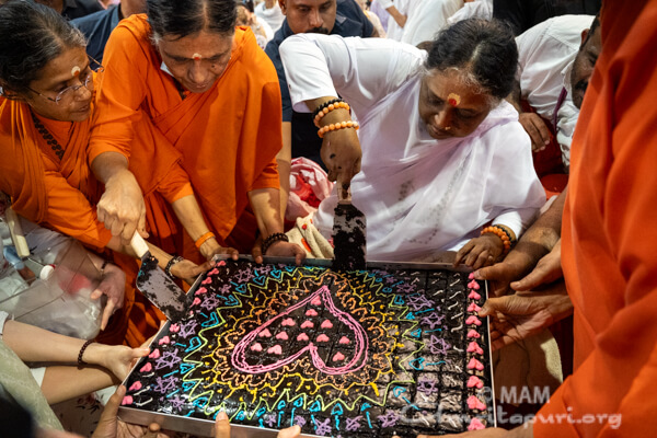 Amma distributing Christmas cake in Amritapuri