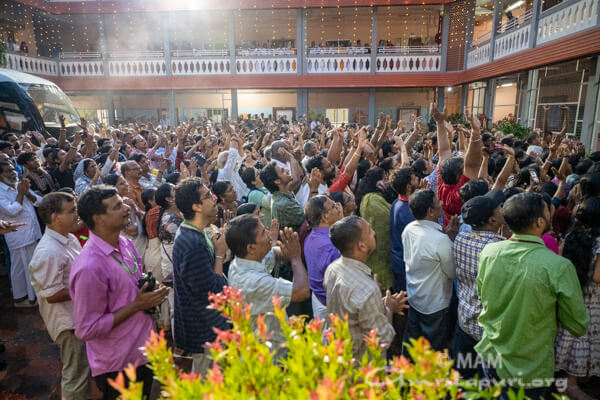 People are cheering as Amma stands on the balcony