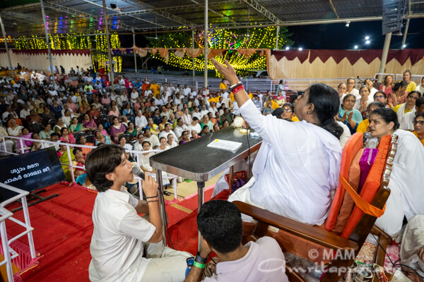 Amma singing bhajans with the volunteers