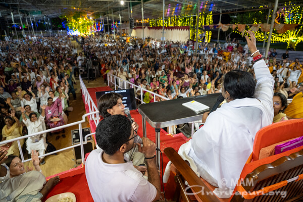Amma singing bhajans with the volunteers